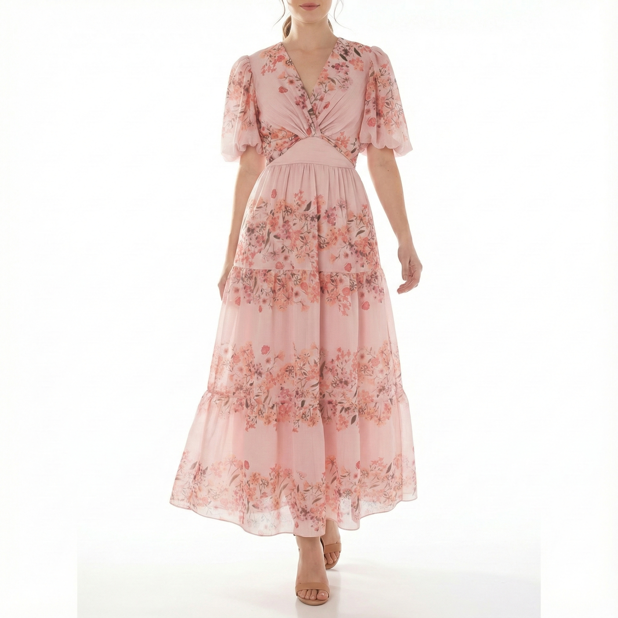Blush pink floral chiffon maxi dress with short puff sleeves, V-neck twist bodice, fitted waist, and tiered skirt, shown from the front.