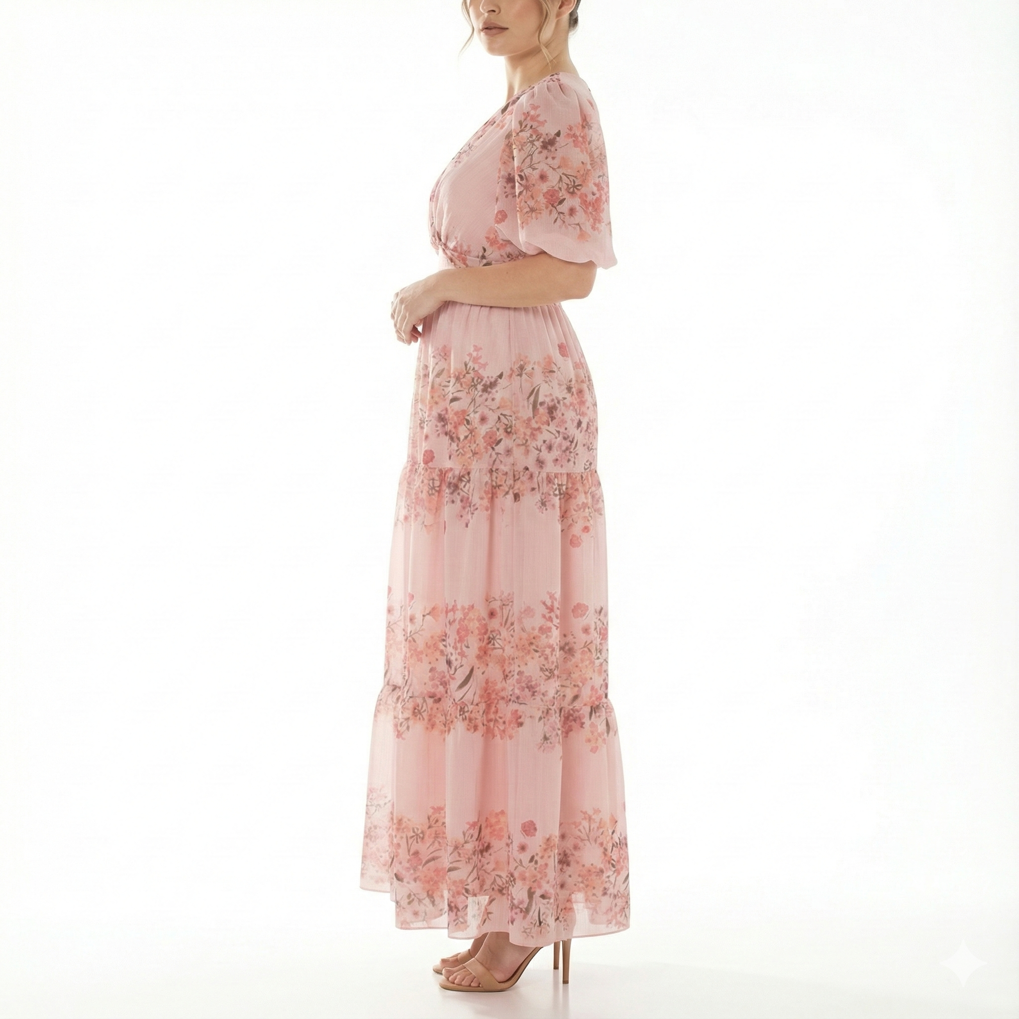 Side view of blush pink floral chiffon maxi dress featuring short puff sleeves, flowing tiered skirt, and lightweight semi-sheer fabric.
