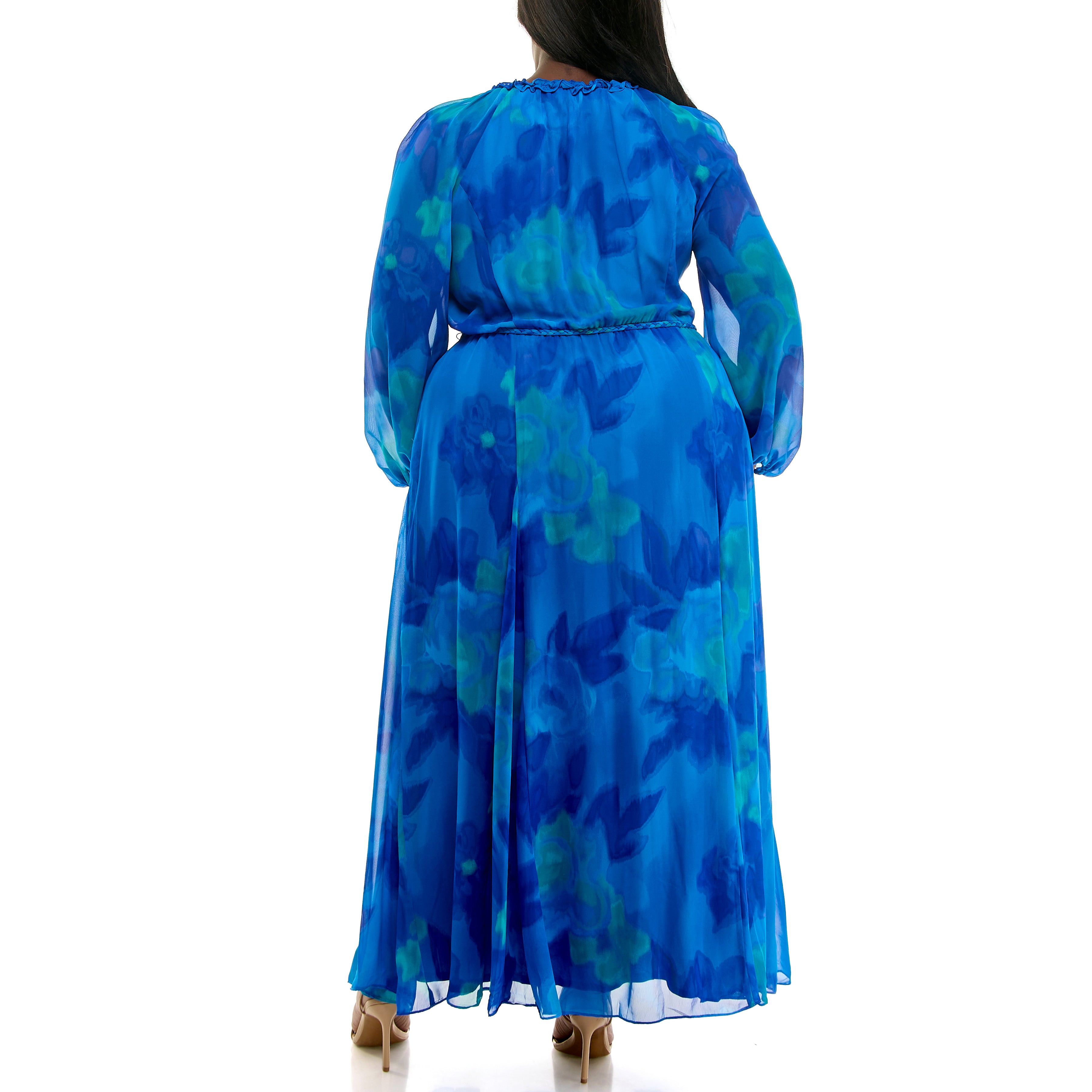 Back view of a plus-size woman wearing a long, flowing blue and teal floral chiffon maxi dress with long sheer sleeves, a gathered neckline, and a braided waist tie, paired with nude high-heel sandals