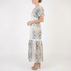 Side view of women’s romantic beige floral midi dress with puff sleeves, lace waist detail, and soft flowing skirt.