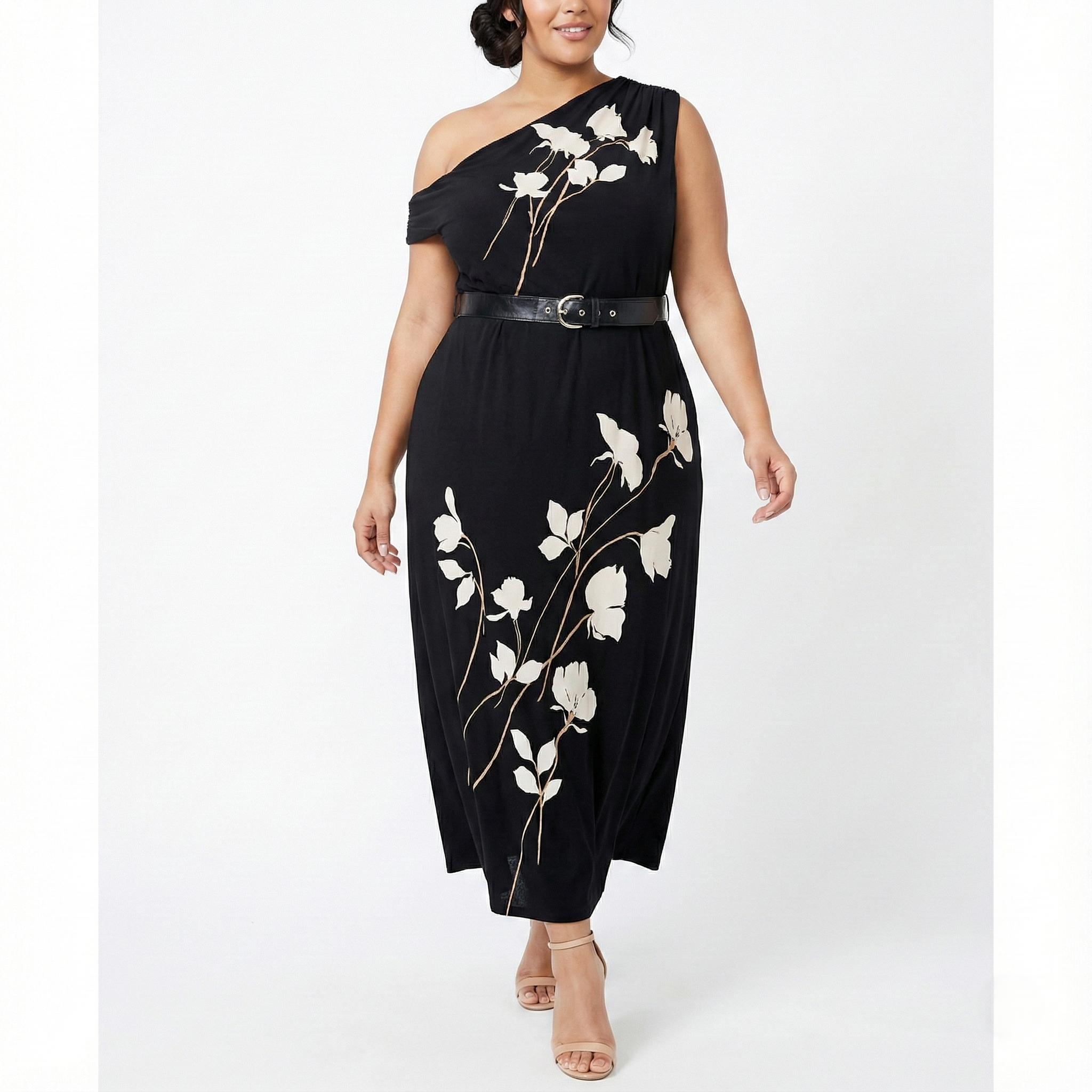 Plus-size black one-shoulder maxi dress with white floral print, belted waist, and flowing skirt, shown from the front on a model.