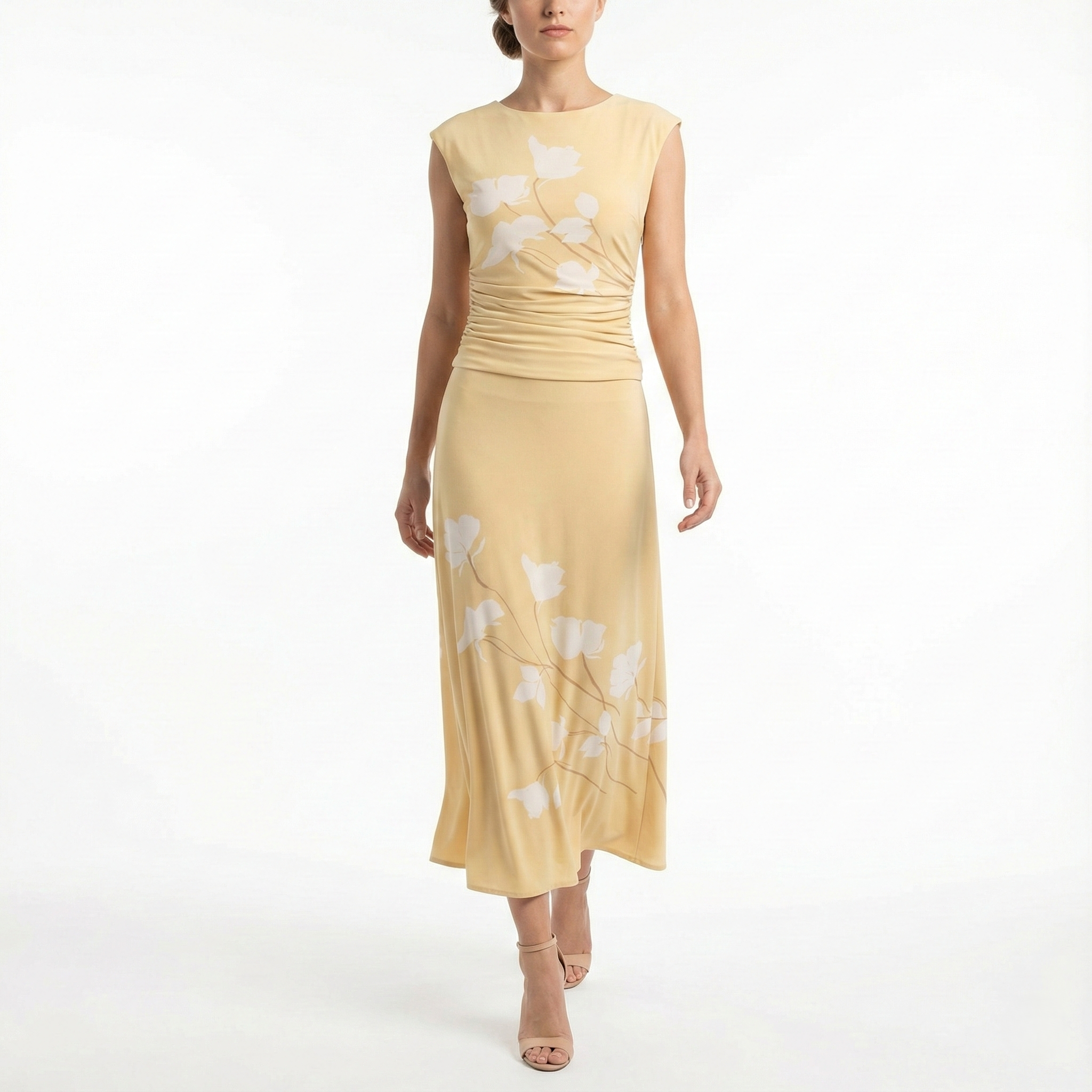 Model wearing a cornsilk yellow sleeveless midi dress with soft white floral print, ruched waist, and flowy skirt, styled with nude high-heel sandals.