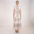 Full back view of blush pink floral chiffon maxi dress featuring flutter sleeves, smocked waist detail, soft floral print, and tiered maxi skirt.