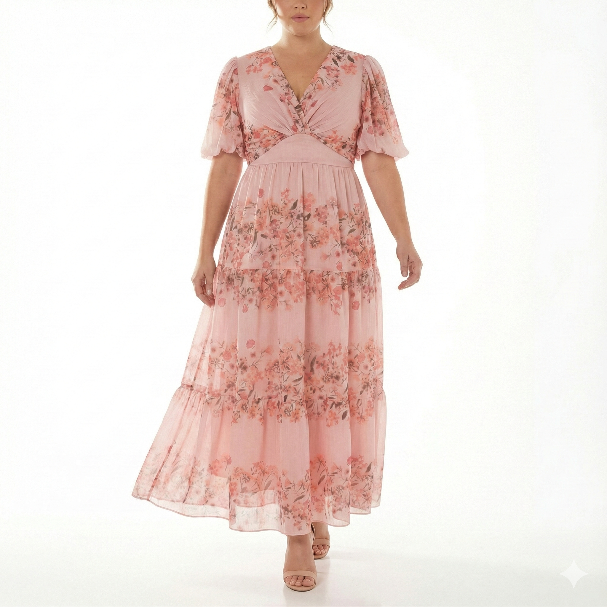 Front view of blush pink floral chiffon maxi dress with short puff sleeves, V-neck twist bodice, fitted waist, and flowing tiered skirt.