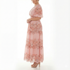 Side profile of blush pink floral chiffon maxi dress with puff sleeves, empire waist, and soft tiered maxi skirt.