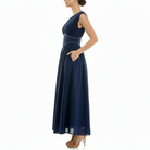 Navy blue sleeveless midi dress with empire waist, soft pleating, and side pockets, side profile view.