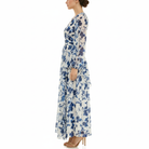 Side view of women’s long-sleeve blue floral maxi dress featuring sheer chiffon fabric, empire waist, and lightweight flowing silhouette.