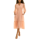 Model wearing a peach chiffon midi dress with a V-neckline, button-front detail, sheer three-quarter sleeves, elastic waist, and side pockets, paired with nude ankle-strap heels.