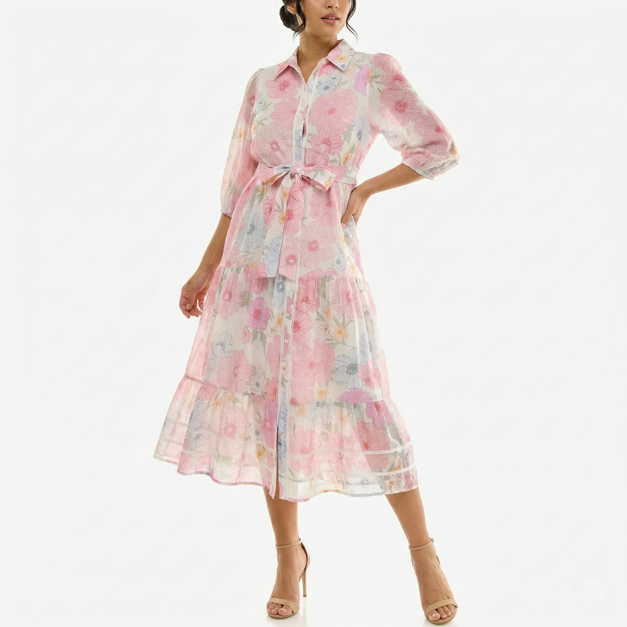 Model wearing a sheer pastel pink floral midi dress with buttons down the front, elbow-length sleeves, and a waist tie, styled with nude high-heel sandals