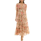 Model wearing a floral chiffon maxi dress with short puff sleeves, ruffled V-neckline, smocked empire waist, and tiered skirt in soft pink and peach tones.